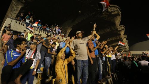 Protesters celebrate in a courtyard after invading the Iraqi parliament. (AFP)