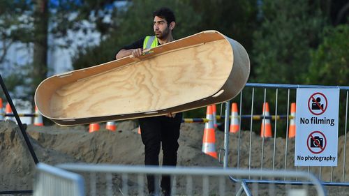 An attendant carries away the casket of Lilik Abdul Hamid, the sixth funeral of the 50 victims of the mosque shootings, at the Memorial Park Cemetery in Christchurch, New Zealand, Wednesday, March 20, 2019. 