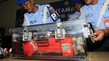 Indonesian Air Force military police officers place the flight data recorder in a savety box. (AAP)