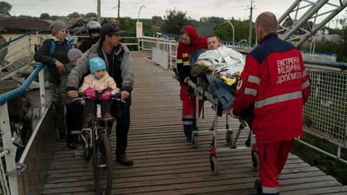 An injured man is carried on a stretcher in the recaptured area of Izium, Ukraine.