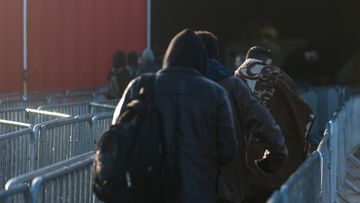 Minor migrants walk the closures towards the registration center in the jungle of Calais in Calais, France, on 25 October 2016. (AFP)
