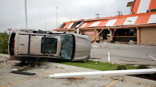 An overturned car lies in the parking lot of a damaged Whataburger in Tulsa. (Photo:AP)