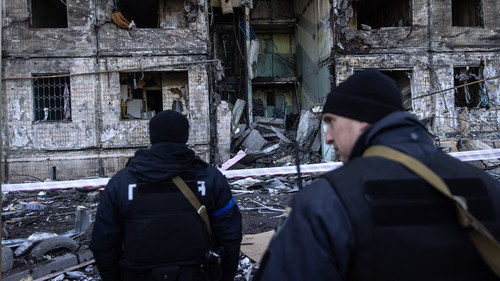 Police stand in front of a residential apartment block that was hit by Russian shelling on March 14, 2022 in Kyiv, Ukraine. 