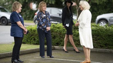 Camilla, Duchess of Cornwall speaks to a worker during a visit with Prince Charles, Prince of Wales to the Turnbull & Asser shirt factory on July 9, 2020 in Gloucester, United Kingdom