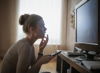 Woman sitting on floor watching tv