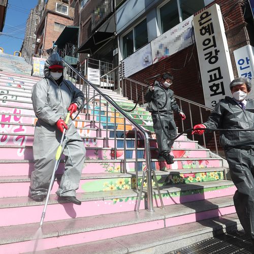 Hygiene officials disinfect an area around temporarily closed River of Grace Community Church in Seongnam, South Korea.