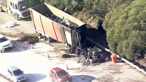 A truck sits burned out on the M1.