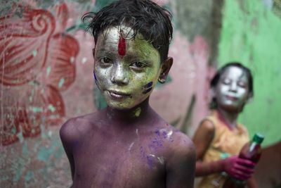 Young children painted in metallic colours celebrate the Holi Festival.