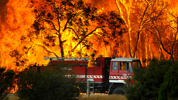 A Country Fire Authority (CFA) fire truck is pictured in front of flames while fighting a bushfire at the Bunyip State Forest near the township of Tonimbuk, Saturday, Feb. 7, 