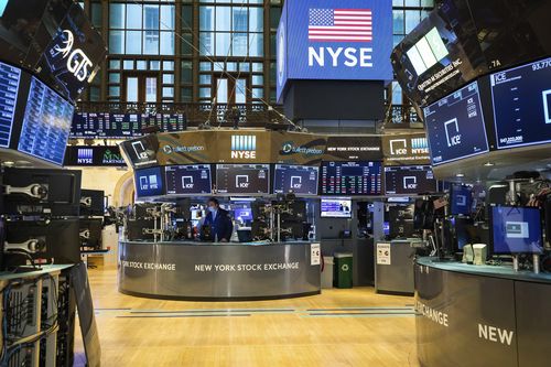 In this photo provided by the New York Stock Exchange, employees work on the partially reopened trading floor, Tuesday, May 26, 2020. Stocks surged on Wall Street in afternoon trading Tuesday, driving the S&P 500 to its highest level in nearly three months, as hopes for economic recovery overshadow worries about the coronavirus pandemic. (Courtney Crow/New York Stock Exchange via AP)