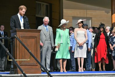 The Prince of Wales, the Duchess of Cornwall and the Duchess of Sussex, listen as the Duke of Sussex speaks during a garden party at Buckingham Palace in London.