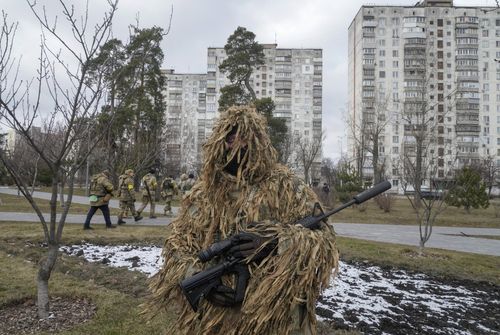 Ukrainian Territorial Defence Forces members pass though the city park in Kyiv outskirts, Ukraine, Wednesday, March 9, 2022