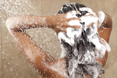 Woman washing her hair with shampoo.