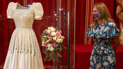 Princess Beatrice poses alongside her wedding dress as it goes on display at Windsor Castle on September 23, 2020 in Windsor, England