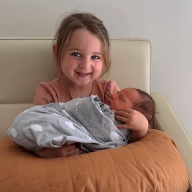 Kayla Itsines' daughter Arna cradles newborn Jax.