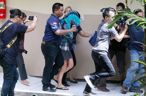 Sara Connor is escorted by police officers in Bali. (AAP)