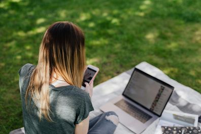 Stock image of a young girl on a phone and laptop.