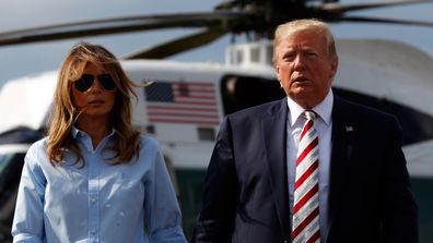 President Donald Trump, with first lady Melania Trump, walks towards the media. 