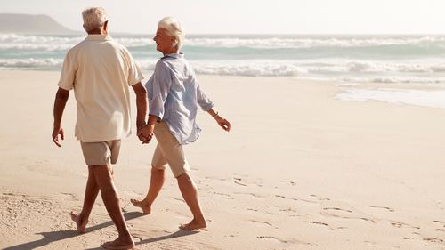 Senior citizens retiree retired old people walking beach 