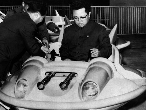 In this October 2, 1977 photo from North Korea's official Korean Central News Agency, distributed by Korea News Service, leader Kim Jon Il has a test drive of a play equipment combat plane in Taesong amusement park. (AP)
