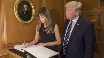 In this image provided by the Supreme Court, President Donald Trump watches as first lady Melania Trump signs the Supreme Court guest book, Thursday, June 15, 2017, at the Supreme Court in Washington.