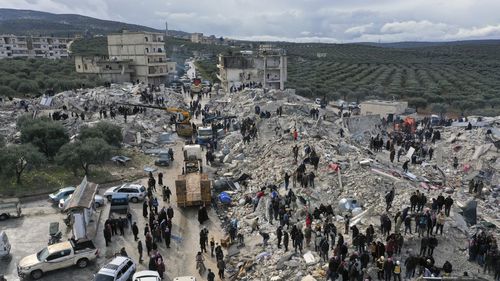 Civil defence workers and residents search through the rubble of collapsed buildings in the town of Harem near the Turkish border, Idlib province, Syria, Monday, Feb. 6, 2023.