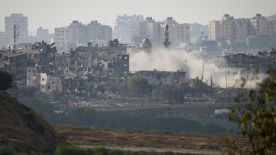 A plume of smoke rises following an artillery strike within Gaza on October 19, 2023, as seen from Sderot, Israel. 