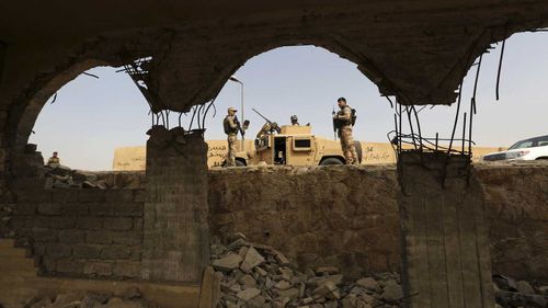 Iraqi troops guard the remains of the Tomb of Jonah mosque. (AAP)