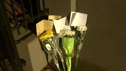 Floral tributes outside Mr Hao's workplace on Bay Street, Brighton. (9NEWS)