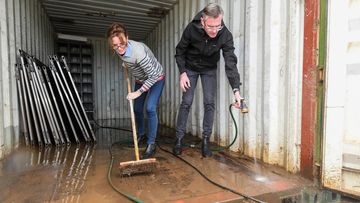 NSW Premier Dominic Perrottet and Emergency Services Minister Stephanie Cooke help with the clean-up at Enzo Cucina, Camden in Sydney&#x27;s south west.