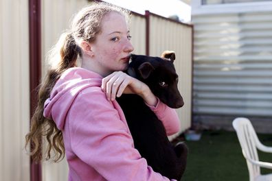 Sahara hugs one of the dogs at the Lort Smith Animal Hospital and The Lost Dogs' Home.