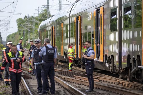 Police officers standing in front of a regional train in Herzogenrath, Germany, Friday, May 13, 2022. 