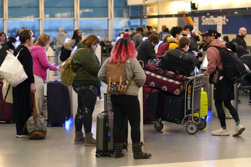 I passeggeri effettuano il check-in presso i chioschi self-service della Southwest Airlines all'aeroporto Midway di Chicago a causa dei ritardi dei voli causati da un'interruzione dei voli di terra della Federal Aviation Administration negli Stati Uniti mercoledì 11 gennaio 2023 a Chicago. 