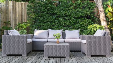 Large terrace patio with rattan garden furniture in the garden on wooden floor