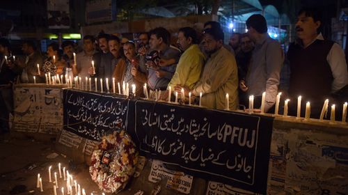 Pakistani journalists light candles for the victims of an attack by Taliban gunmen on a school in Peshawar. (Getty)