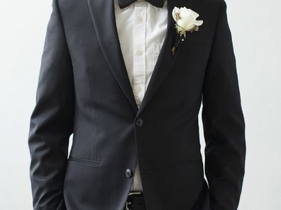 Groom standing in tux