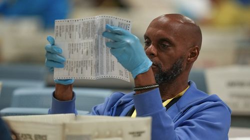 An election worker processes mail-in ballots for the 2024 general election at an election warehouse in Philadelphia.