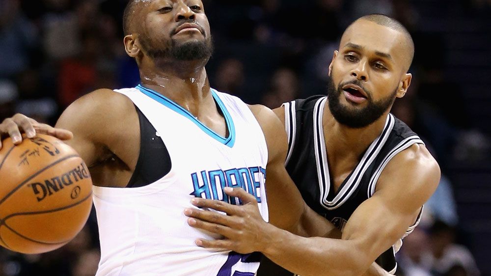 Patty Mills (R) defends the Spurs. (AFP)