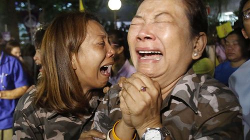 People cry after Royal Palace's announcement outside Siriraj Hospital where Thai King Bhumibol Adulyadej was being treated. (AAP)