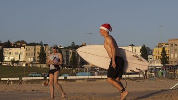 A surfer in a Santa hat in Sydney, Australia on Christmas Day.