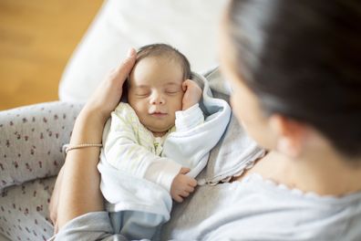 Woman holding newborn baby at home