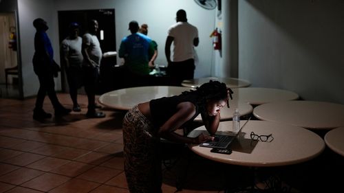 A woman video chats with a friend ahead of Hurricane Melissa's forecast arrival in Kingston, Jamaica, Monday, Oct. 27, 2025. (AP Photo/Matias Delacroix)