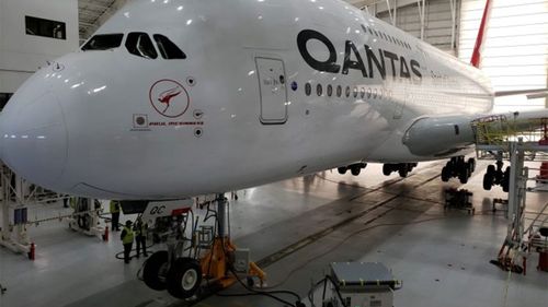 A Qantas jet is put through routine maintenance during its grounding.
