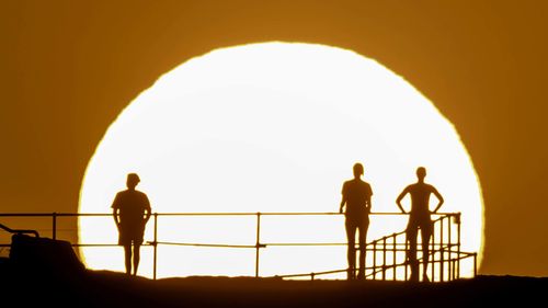  People watch as the sun rises over Ben Buckler Point in Bondi on November 27, 2024 in Sydney, Australia. 