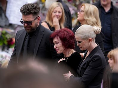 BIRMINGHAM, ENGLAND - JULY 30: Jack Osbourne, Sharon Osbourne, Kelly Osbourne and family members stop to view tributes to the late Ozzy Osbourne from fans at Black Sabbath Bench and Bridge as his funeral cortege travels through his home city of Birmingham on July 30, 2025 in Birmingham, England. The Black Sabbath frontman passed away on July 22nd at the age of 76. His death occurred just a little over two weeks after his final live performance at the 'Back to the Beginning' concert in his hometo