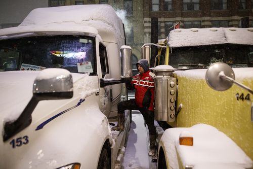 A man speaks with another inside a truck as people gather during a protest against COVID-19 measures that has grown into a broader anti-government protest that continues to occupy downtown Ottawa, Ontario, on Thursday, Feb. 17, 2022