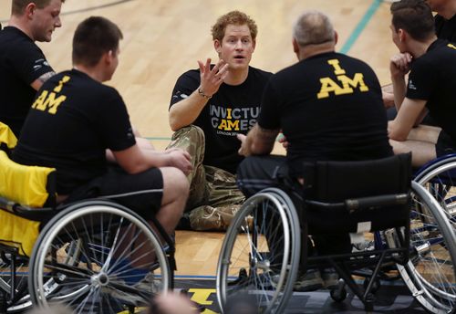 Britain Prince Harry, center, speaks to the wheelchair basketball competitors during the launch of the Invictus Games for wounded warriors at the Copper Box arena in the Queen Elizabeth Olympic Park in London, Thursday, March 6, 2014.  The international games for invalided military personnel will be held in London in Sept. 10-14, 2014 with more than 300 competitors from across the world competing in eight adaptive sports. Invictus translates from Latin to mean undefeated, hence the games' slogan