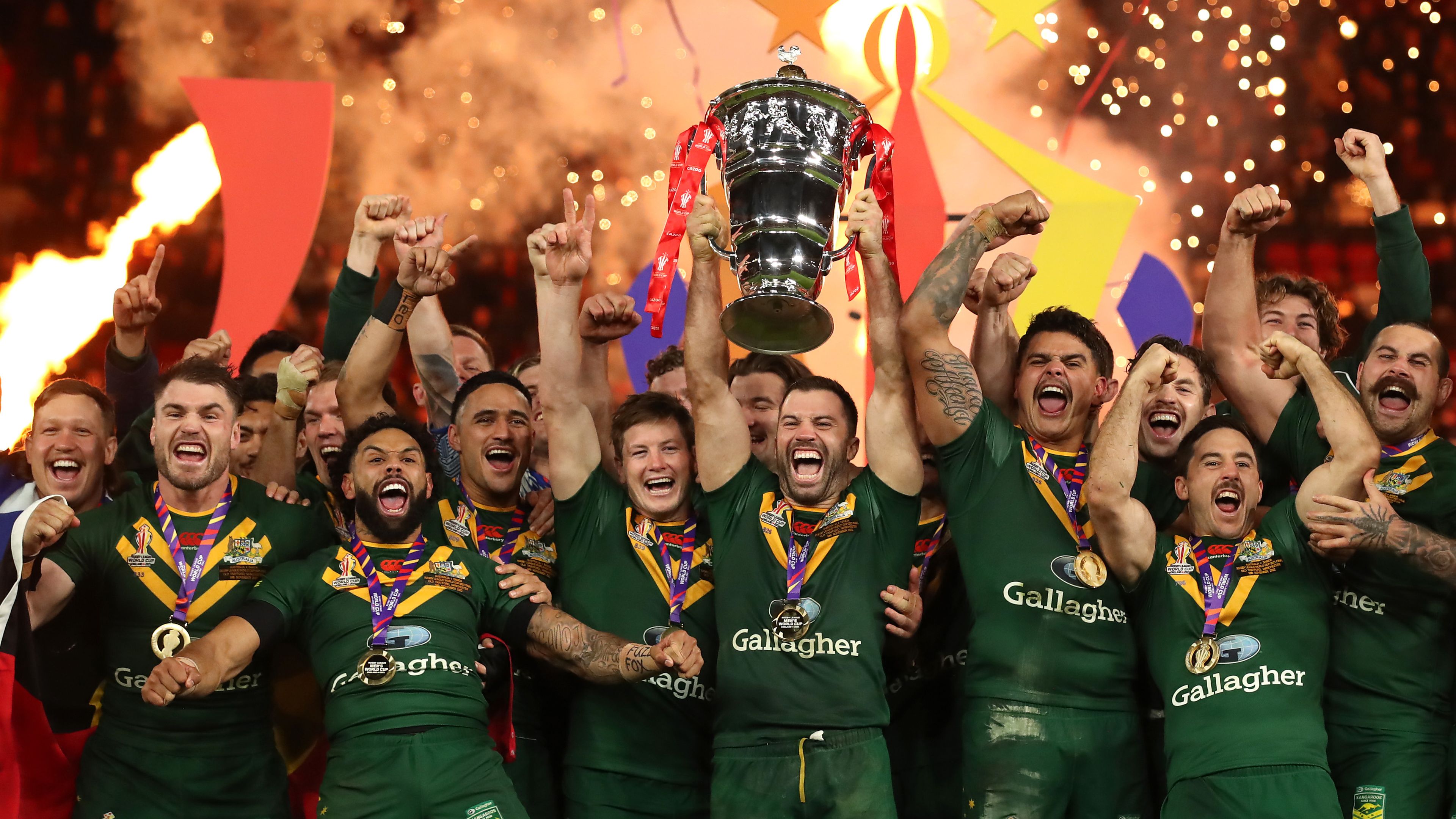 MANCHESTER, ENGLAND - NOVEMBER 19: James Tedesco of Australia lifts the Rugby League World Cup trophy with teammates following victory during the Rugby League World Cup Final match between Australia and Samoa at Old Trafford on November 19, 2022 in Manchester, England. (Photo by Jan Kruger/Getty Images for RLWC)