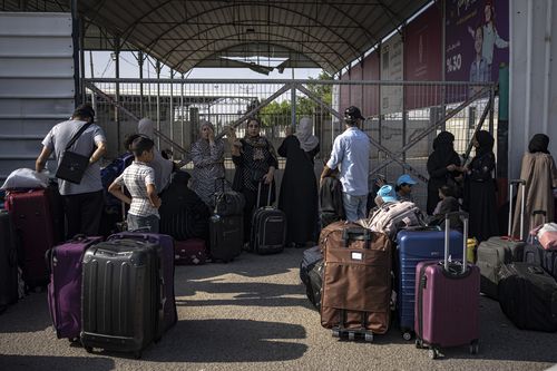 Palestinians wait to cross into Egypt at Rafah, Gaza Strip, on Wednesday, Nov. 1, 2023.  