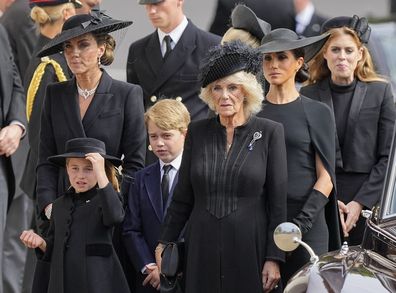 Кейт, принцеса на Уелс, принцеса Шарлот, принц Джордж, Камила, съпруг, Меган, херцогиня на Съсекс и принцеса Беатрис следват ковчега на кралица Елизабет II след нейното погребение